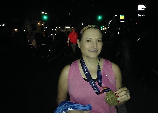 Lisa O’Brien-Russell, RN, OCN showing her medal after a marathon